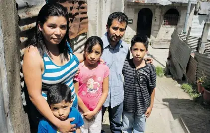  ?? MOISES CASTILLO/THE ASSOCIATED PRESS ?? Gregoria Contreras, 35, with her husband and their three children in Guatemala City, where she now lives. Contreras was four when she was taken from her parents by a Salvadoran soldier, who registered her under a new name, forcibly adopted her, and...