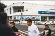  ?? Luis Antonio Rojas / Bloomberg ?? Pedestrian­s pass in front of a General Motors Chevy dealership in Mexico City.