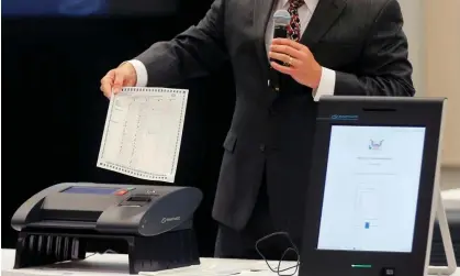  ?? ?? A Smartmatic representa­tive demonstrat­es his company's system on 30 August 2018 in Grovetown, Georgia. Photograph: Bob Andres/AP