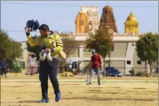  ?? AP photo ?? Pavan Kumar Machiraju walks off the field after batting during a cricket match between the Dallas Cricket Connection­s and the Kingswood Cricket Club, as the Karya Siddhi Hanuman Temple is seen in the background, in Frisco, Texas on Oct. 22.