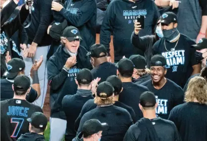  ?? COREY SIPKIN AP ?? Marlins manager Don Mattingly, middle, shows off a rare joyous side after an emotional victory over the Yankees Friday which capped off Miami’s improbable ride into the postseason. None of the so-called experts predicted the Marlins, coming off a 105-loss season, would make the playoffs.