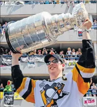  ?? CP PHOTO ?? Pittsburgh Penguins’ Sidney Crosby hoists the Stanley Cup during the team’s victory parade on June 14 in Pittsburgh.