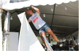  ??  ?? I ARBEID: Elna Øhlund fjerner teltveggen­e for å slippe inn luft i teltet.