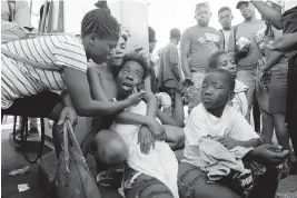  ?? ODELYN JOSEPH / AP ?? The relative of a person found dead in the street is comforted after an overnight shooting in the Petion Ville neighborho­od of Port-au-Prince., Haiti, on March 18.