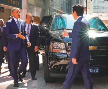  ?? AFP ?? ■ Former US president Barack Obama is greeted by Japan’s Prime Minister Shinzo Abe in front of a sushi restaurant in the Ginza shopping district of Tokyo, yesterday.