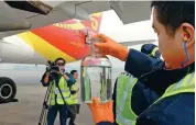  ?? XINHUA ?? Hainan Airlines’ ground staff display a biofuel that is used in aviation, in Beijing on Nov 22, 2017.