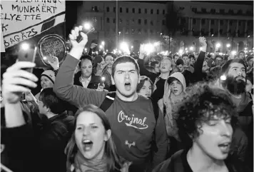  ?? ATTILA KISBENEDEK/AGENCE FRANCE-PRESSE VIA GETTY IMAGES ?? People shout slogans against Hungarian Prime Minister Viktor Orban's government in front of the parliament building Wednesday during their demonstrat­ion in Budapest.