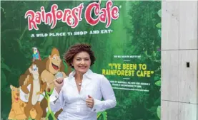  ??  ?? Clare Agius with the hoarding of Rainforest Cafe restaurant in St Julian’s