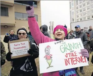  ?? Carolyn Kaster Associated Press ?? A WOMAN holds a sign with an image of FCC Chairman Ajit Pai as the “Grinch who Stole the Internet” to protest the recent eliminatio­n of net-neutrality protection­s.