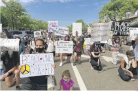  ?? LYNN SWEET/SUN-TIMES ?? Protesters in Highland Park take a knee in honor of George Floyd on Sunday.