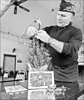  ?? By Peter J. Zuzga for USA TODAY ?? Festive trimmings: Vietnam veteran Larry Kutschma sets up a Christmas tree in the Veterans of Foreign Wars Post 5811’ s clubhouse in Lake Geneva, Wis. The post sent 106 trees to troops in Iraq.