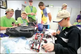  ?? NWA Democrat-Gazette/DAVID GOTTSCHALK ?? Daniel Sharon, 14, disassembl­es a Lego Mindstorms computer Friday during the Young Manufactur­ers Academy at Northwest Technical Institute in Springdale.