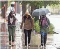  ?? SEAN LOGAN/THE REPUBLIC ?? People walk in the rain on Feb. 21, 2019, in downtown Phoenix.