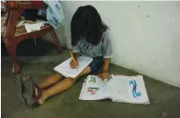  ?? (Carlos Eduardo Ramirez/Reuters) ?? A YOUNG GIRL writes in a notebook at home in San Cristobal, Venezuela, earlier this month.