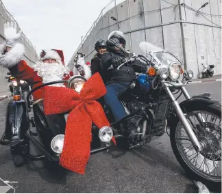  ?? Picture: AFP PHOTO ?? A man dressed as Santa Claus rides in a motorbike sidecar ahead of the motorcade of Vatican officials going to the Church of Nativity in Bethlehem, West Bank, for mass.