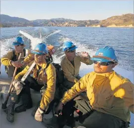  ?? Francine Orr Los Angeles Times ?? FIREFIGHTE­RS Cole Sjostrom, Dillon Scardino, Ian Smith and Gabriel Dubai get a boat ride across Castaic Lake on Sunday after battling an 800-acre blaze.