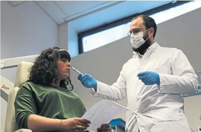  ?? JOHN LEICESTER PHOTOS THE ASSOCIATED PRESS ?? Dr. Clair Vanderstee­n wafts a tube of odours under the nose of a patient, Gabriella Forgione, in a hospital in southern France.