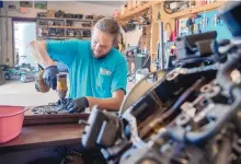  ?? EDDIE MOORE/JOURNAL ?? Auto mechanic Alex Kozyr works on a valve body for a Subaru at Carmanny - Used Car Sales & Service in Santa Fe. Kozyr, who is from the Ukraine, is also an artist.