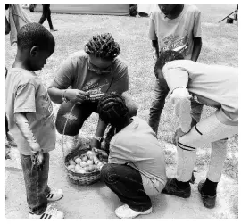  ??  ?? Supreme Ventures Vice-President of Marketing, Communicat­ion and Sponsorshi­ps Gail Abrahams collects the plastic eggs brought to her by her Cocomint housemates.