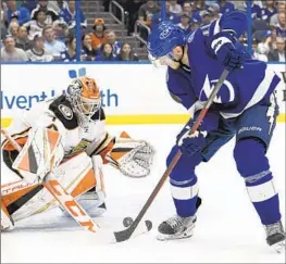  ?? Jason Behnken Associated Press ?? COREY PERRY of Tampa Bay looks to shoot against his former team as goaltender Lukas Dostal, who made 38 saves, defends during the second period.