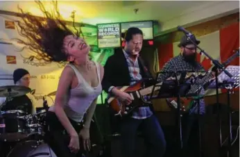  ?? BERNARD WEIL/TORONTO STAR ?? Lisa Hui dances as the band Awesome Studio plays at the Earl of Whitchurch pub in Stouffvill­e, Ont. The pub has already broken a record for the longest concert streamed online, and now its sights are set on a bigger record.