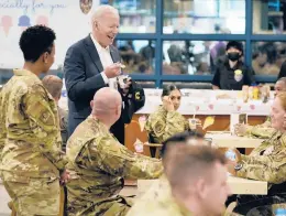  ?? EVAN VUCCI/AP ?? U.S. President Joe Biden eats ice cream during a visit with American service members on Sunday at Osan Air Base in Pyeongtaek, South Korea.