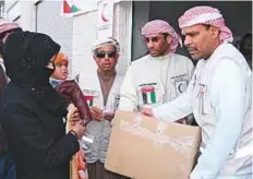  ?? WAM ?? Emirates Red Crescent volunteers distributi­ng aid to Syrian refugees living in camps on the Syria-Jordan border.