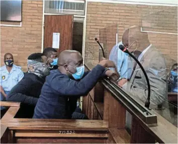  ?? /MANDLA KHOZA ?? Former Mpumalanga MEC Mandla Msibi talks to his relatives during his appearance in the Nelspruit magistrate’s court.