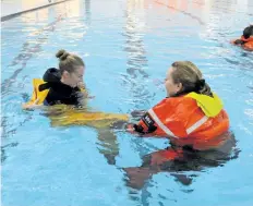  ?? DAVE JOHNSON/ WELLAND TRIBUNE ?? Port Colborne Marine Auxiliary Rescue unit training officer Amber Dashwood, left, is helped by unit secretary Nancy Sider on Sunday during training in Port Colborne. Dashwood was attempting to get out of her floater suit in the pool at the Vale Health...