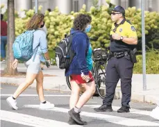  ?? FILE ?? A Temple University police officer directs traffic at a crosswalk inside Temple’s campus in Philadelph­ia.