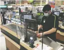  ?? CP PHOTO / JONATHAN HAYWARD ?? A plexiglass barrier is pictured creating a barrier to protect a cashier at a grocery store in North Vancouver, B.C. Sunday.