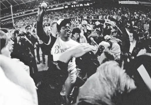  ?? MANNY RUBIO/USA TODAY SPORTS ?? Hank Aaron proudly displays the ball he hit for his 715th home run on April 8, 1974, at Fulton County Stadium in Atlanta.