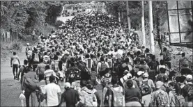  ?? JOHN MOORE/GETTY ?? Honduran immigrants walk north Tuesday in a caravan near Esquipulas, Guatemala.