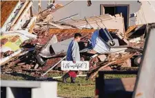  ?? ?? Logan Johnson, 11, carries a sign that reads “Thankful” after he recovered it from his family’s destroyed home in Powderly. At least two dozen people were injured in Lamar County.