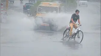  ?? HIMANSHU VYAS/HT ?? A man wades through a water-logged street as heavy rainfall lashes Jaipur on Monday.