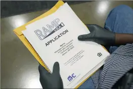  ?? ROGELIO V. SOLIS — THE ASSOCIATED PRESS FILE ?? An applicant waits with paperwork at a rental assistance fair in Jackson, Miss.