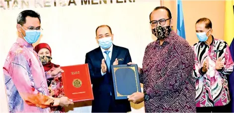  ??  ?? Hajiji and Nancy witnessing the exchange of MoU between the National Visual Arts Developmen­t Board and Universiti Malaysia Sabah.