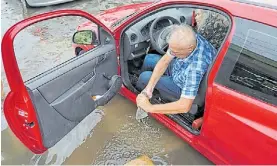  ?? M. BONETTO ?? Daños. En Avellaneda, un conductor saca agua de su auto.