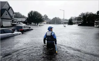  ?? DAVID GOLDMAN / AP ?? A member of a North Carolina urban search and rescue team wades through a flooded neighborho­od in Fayettevil­le on Sunday looking for residents who stayed behind as Florence continues to dump heavy rain in the area. All 100 of North Carolina’s counties are on some degree of weather alert.