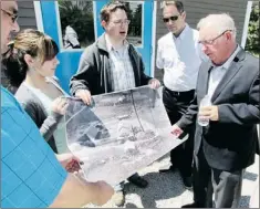  ?? — Photo by Rebekah Ward/special to The Telegram ?? Field site experts pore over an aerial photograph of the First World War Admiralty House structure with Mount Pearl city council representa­tives. From left are: Melanie Stockley, James Lyttleton, Deputy Mayor Jim Locke and Mayor Randy Simms.