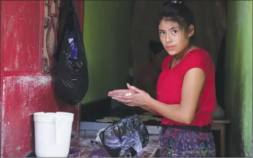  ?? (AP/Moises Castillo) ?? Florinda, 20, from Guatemala’s Quiche province, makes handmade corn tortillas Oct. 16 near La Palmita market in Guatemala City. Florinda came to the capital four years ago from the western mountainou­s area and has worked making tortillas ever since. She generally works seven days a week.