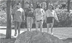  ?? ROBERT FRANKLIN/SOUTH BEND TRIBUNE VIA AP ?? Students wear masks at the University of Notre Dame on Aug. 18 in South Bend, Ind., where in-person undergradu­ate classes were canceled for two weeks after a spike of coronaviru­s cases.