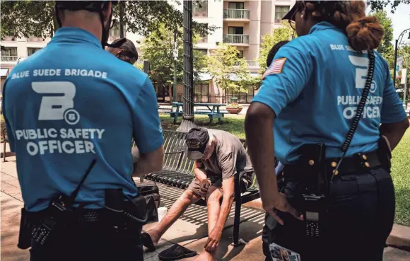  ??  ?? Robert Montgomery, left, and Liza Wheaten with the Blues Suede Brigade, attend to a homeless man in need of medical attention in Downtown Memphis. They stayed with the man until emergency medical technician­s arrived. WILLIAM DESHAZER / FOR THE MARSHALL PROJECT