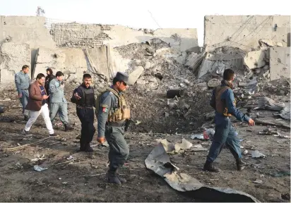  ?? (Omar Sobhani/Reuters) ?? AFGHAN POLICEMEN inspect at the site of a blast in Kabul yesterday.