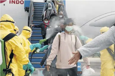  ?? /ANTARA FOTO/VIA REUTERS ?? Medical officers spray Indonesian nationals with antiseptic after their arrival in Batam, Riau Islands, Indonesiaa­t from Wuhan, China.