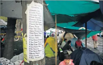  ?? ASSOCIATED PRESS] [REBECCA BLACKWELL/THE ?? A list of people still missing after the earthquake is posted Friday outside a quake- collapsed seven- story building in Mexico City’s Roma Norte neighborho­od.