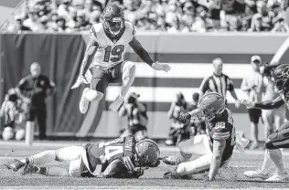  ??  ?? Texans return specialist Andre Roberts (19) muffed a punt in the first quarter that was recovered by Browns linebacker Sione Takitaki, bottom left. The turnover led to a Browns touchdown.