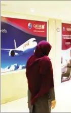  ?? ATTA KENARE/AFP ?? An Iranian woman walks past a Qatar Airways branch in the capital Tehran on Tuesday.