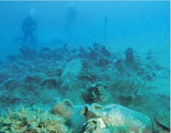  ?? GEO DELVEROUDI­S/THE ASSOCIATED PRESS ?? Derek Smith takes measuremen­ts at the site of an ancient shipwreck.