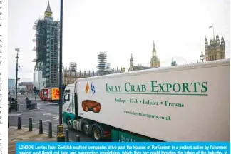  ?? — AFP ?? LONDON: Lorries from Scottish seafood companies drive past the Houses of Parliament in a protest action by fishermen against post-Brexit red tape and coronaviru­s restrictio­ns, which they say could threaten the future of the industry, in London on Monday.